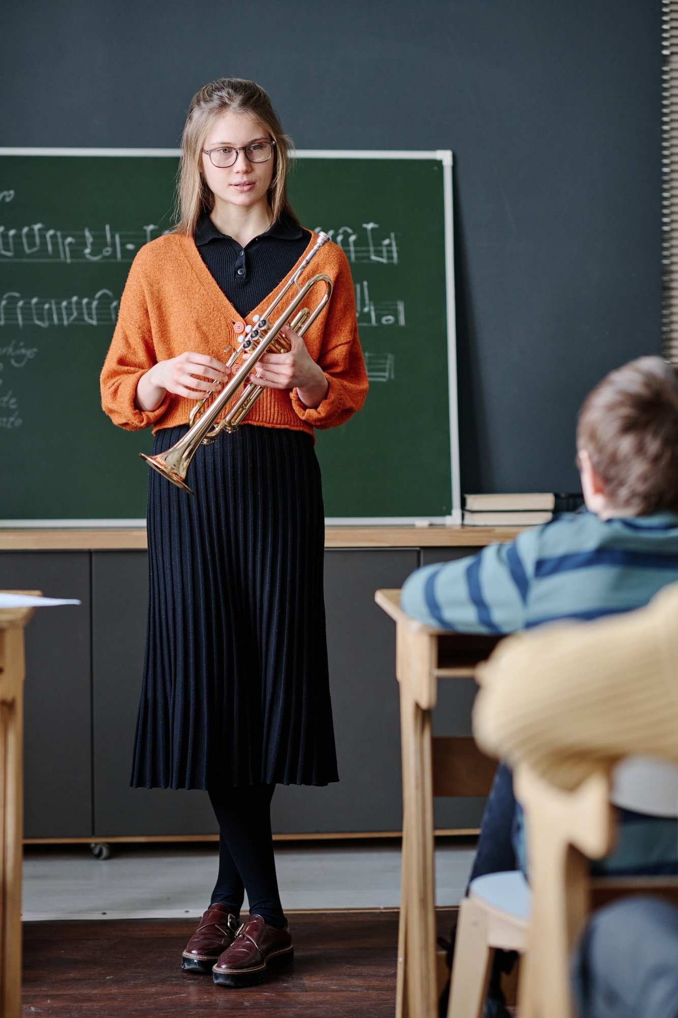 Young Music Teacher Holding Trumpet Conducting Lesson